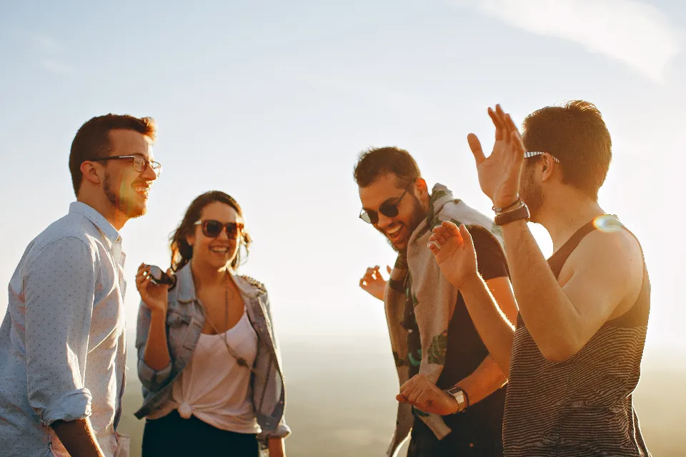 Grupo de amigos jóvenes riendo al atardecer